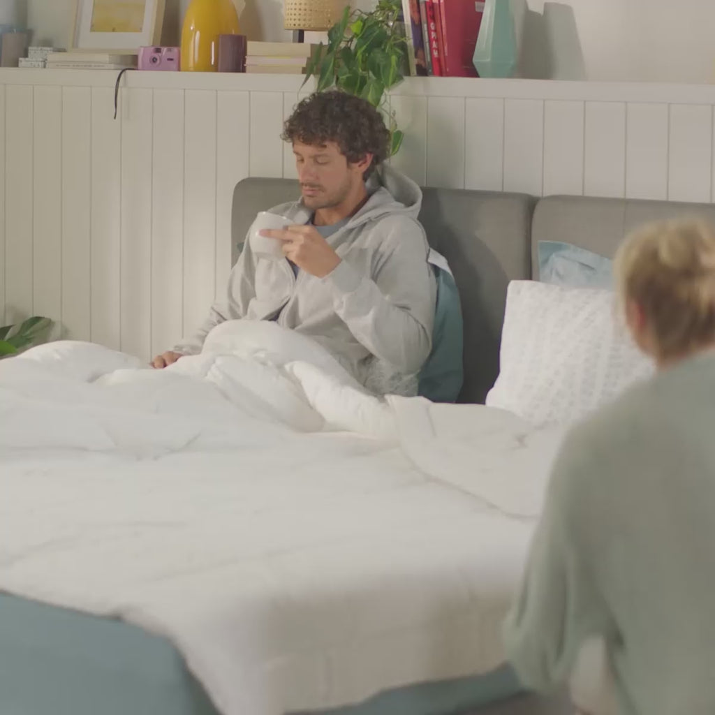 Homem e mulher na cama, exibindo o edredon branco